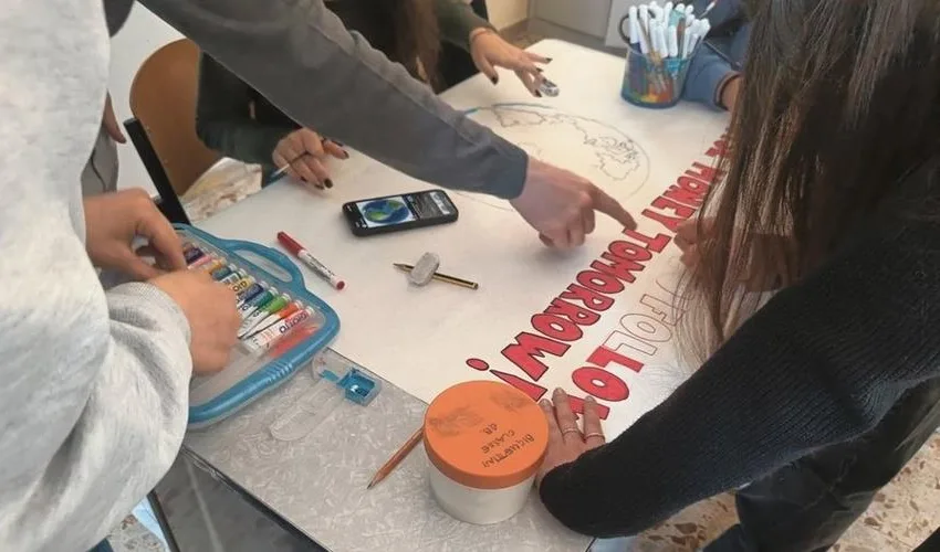 Studenti al lavoro su un cartellone durante un laboratorio di educazione finanziaria